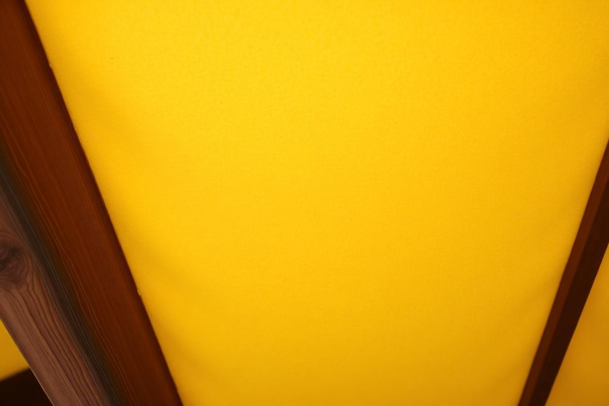 Close-up of yellowed closed-cell spray foam between roof rafters